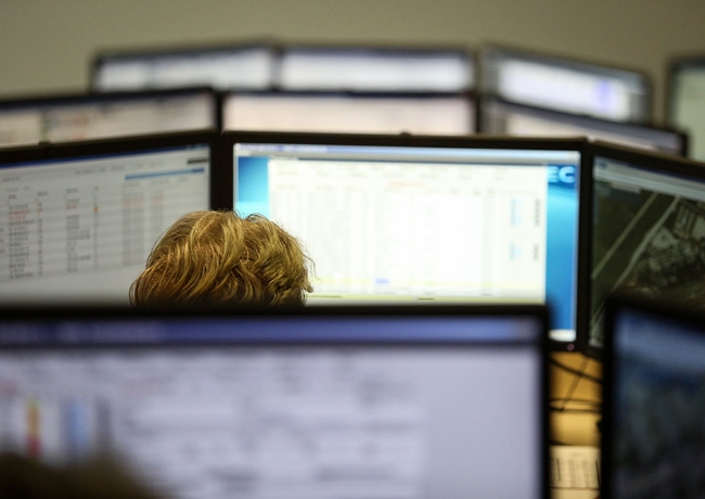 worker-surrounded-by-compuer-screens