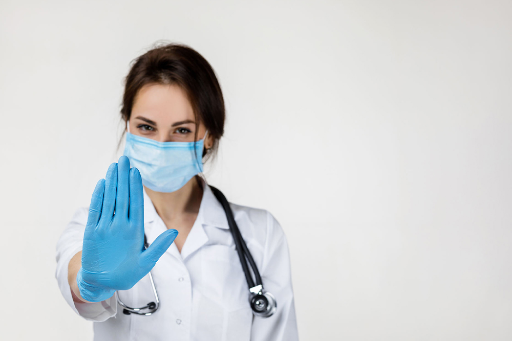 young-female-doctor-holding-up-hand-wearing-latex